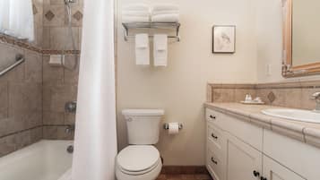 A bathroom with a bathtub, toilet, sink, and towel rack.