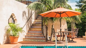 A swimming pool with a tiled border, a potted plant, and a staircase with colorful tiles. - Brisas del Mar, Inn at the Beach (Santa Barbara)
