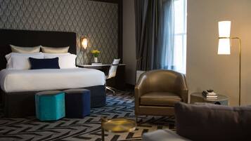 Une chambre d’hôtel avec un grand lit, un bureau, une chaise et une lampe.