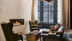 Una sala de estar moderna con chimenea, sillones de cuero, un sofá y una mesa de centro.