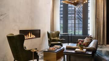 A modern living room with a fireplace, leather armchairs, a sofa, and a coffee table.