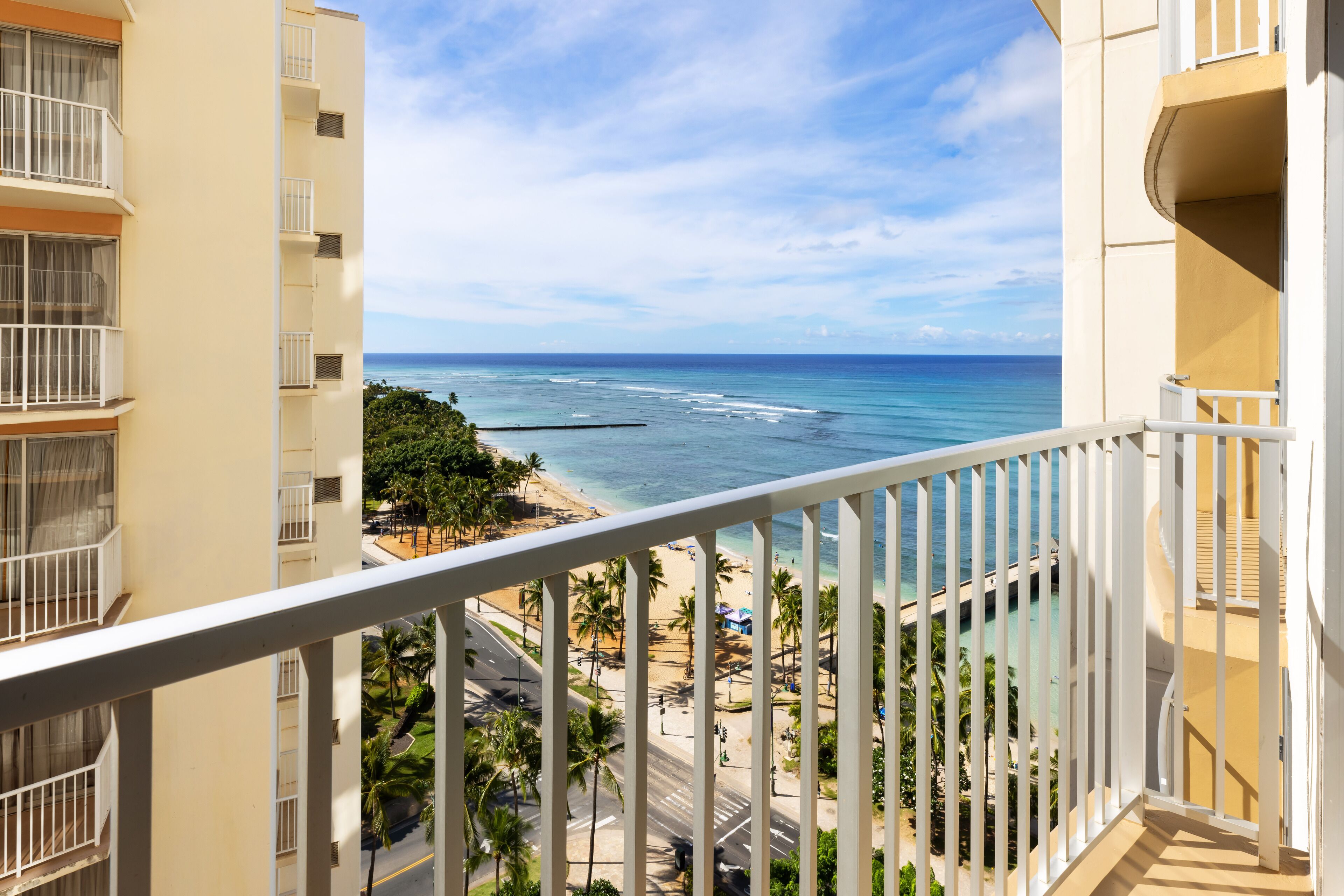 Un balcon avec vue sur une plage et l’océan.