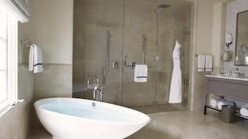 Une salle de bain moderne avec une baignoire sur pieds, une douche à l’italienne et un meuble-lavabo avec un miroir.
