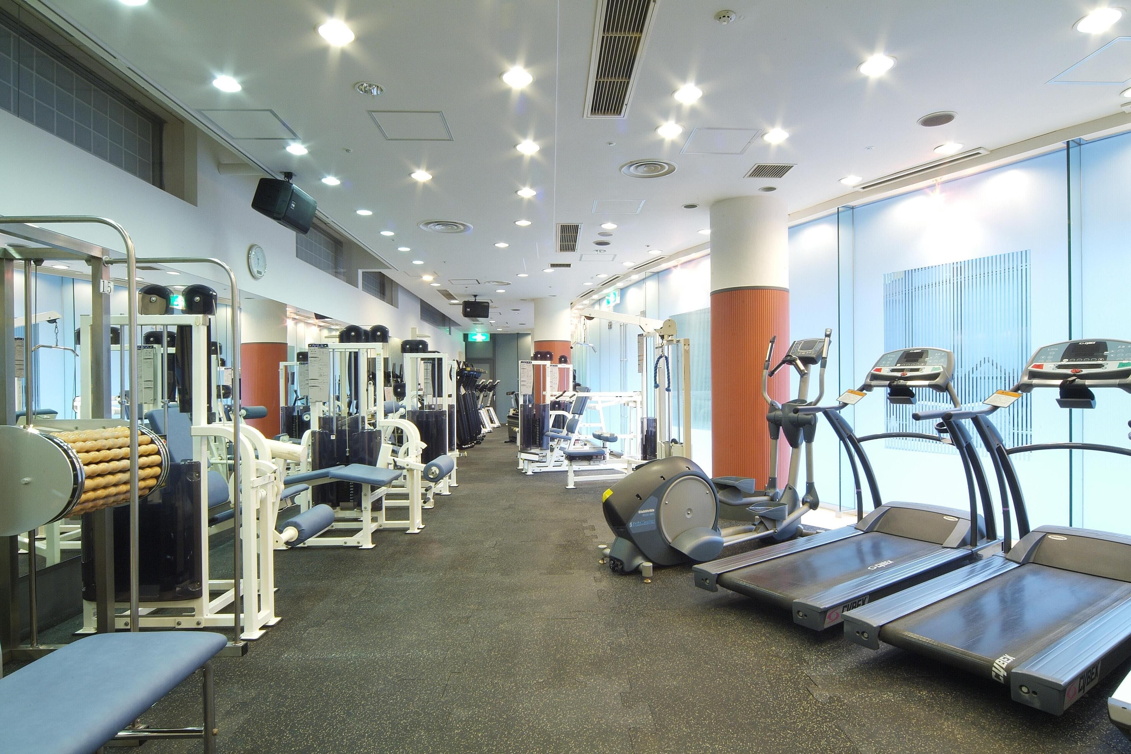 A gym with treadmills, weight machines, and exercise mats.