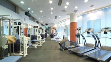 A gym with treadmills, weight machines, and exercise mats.
