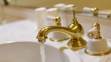 A bathroom sink with a gold faucet and a mirror above it.