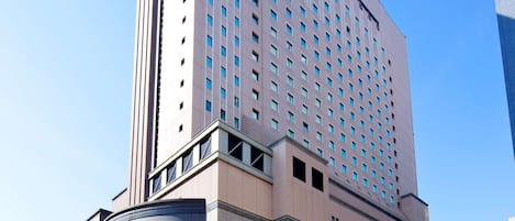 Un hotel de gran altura con una imponente torre de reloj, ventanas amplias y un diseño arquitectónico moderno.