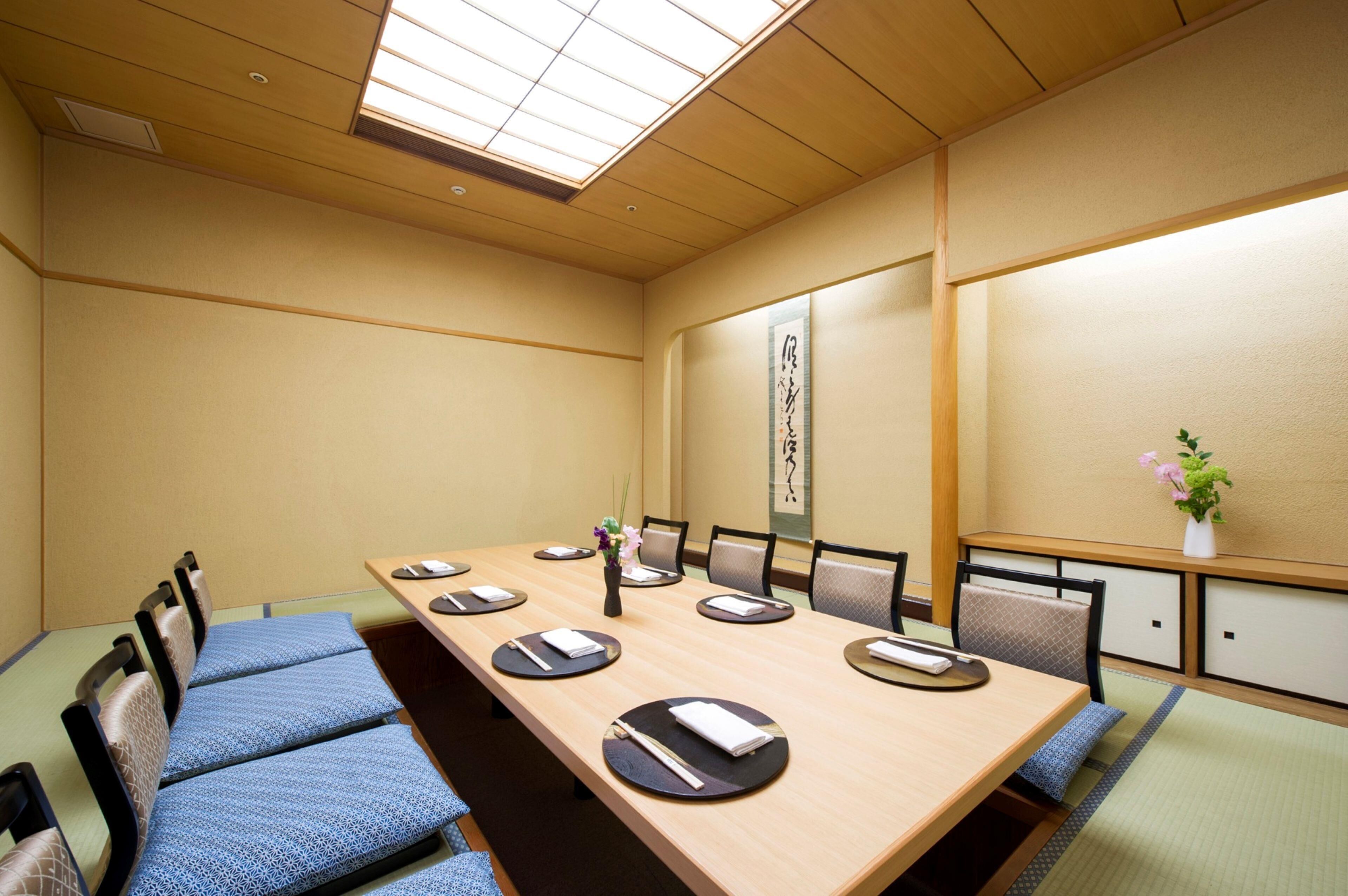 A conference room with a long table, chairs, and a traditional Japanese aesthetic.