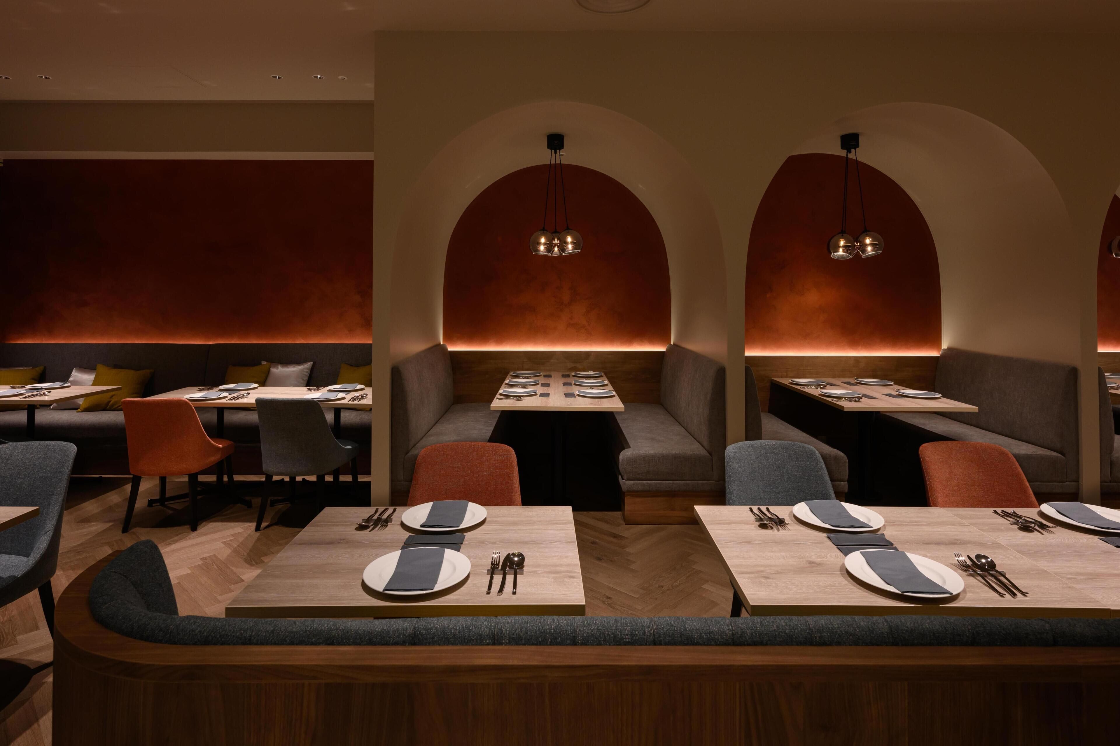 Un restaurante con cabinas, mesas y una iluminación cálida.