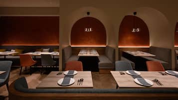 Un restaurante con cabinas, mesas y una iluminación cálida.