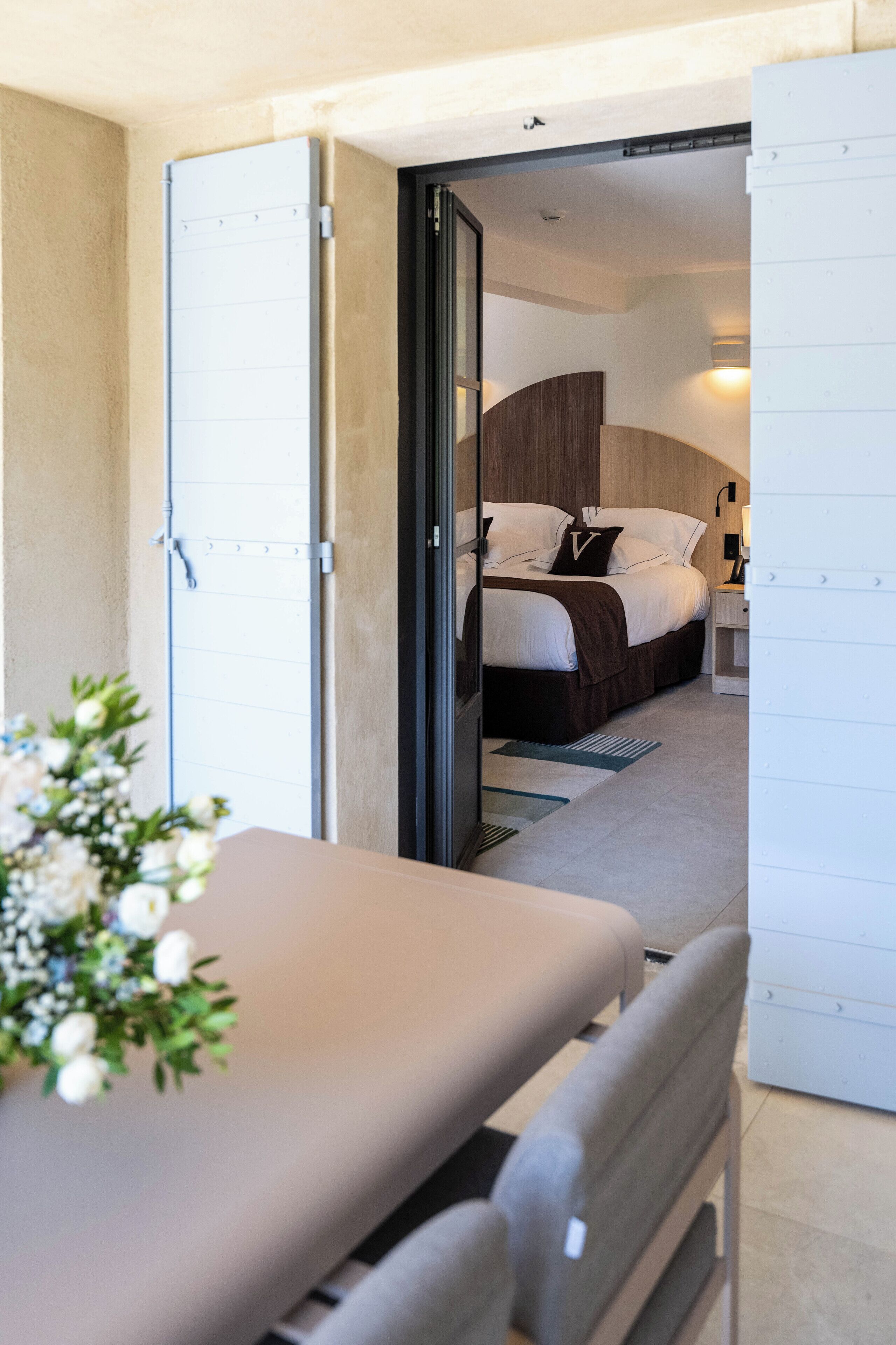 Un dormitorio con cama, mesita de noche y velador.