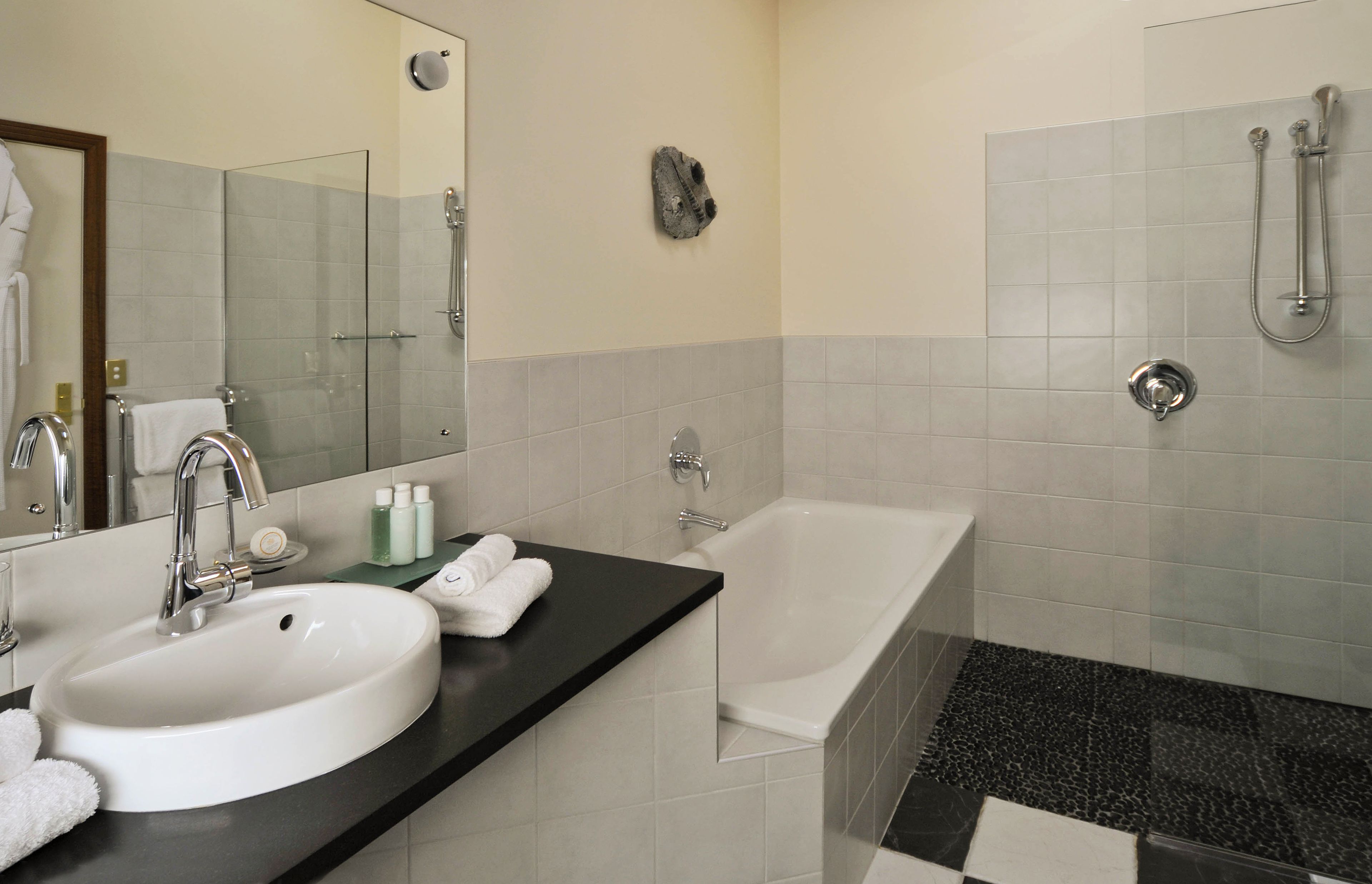 A modern bathroom with a white sink, a bathtub, and a shower.
