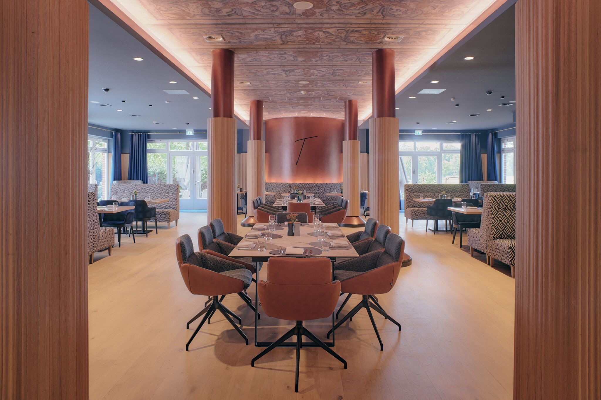 A spacious dining area with a large table set for a meal, surrounded by comfortable seating.