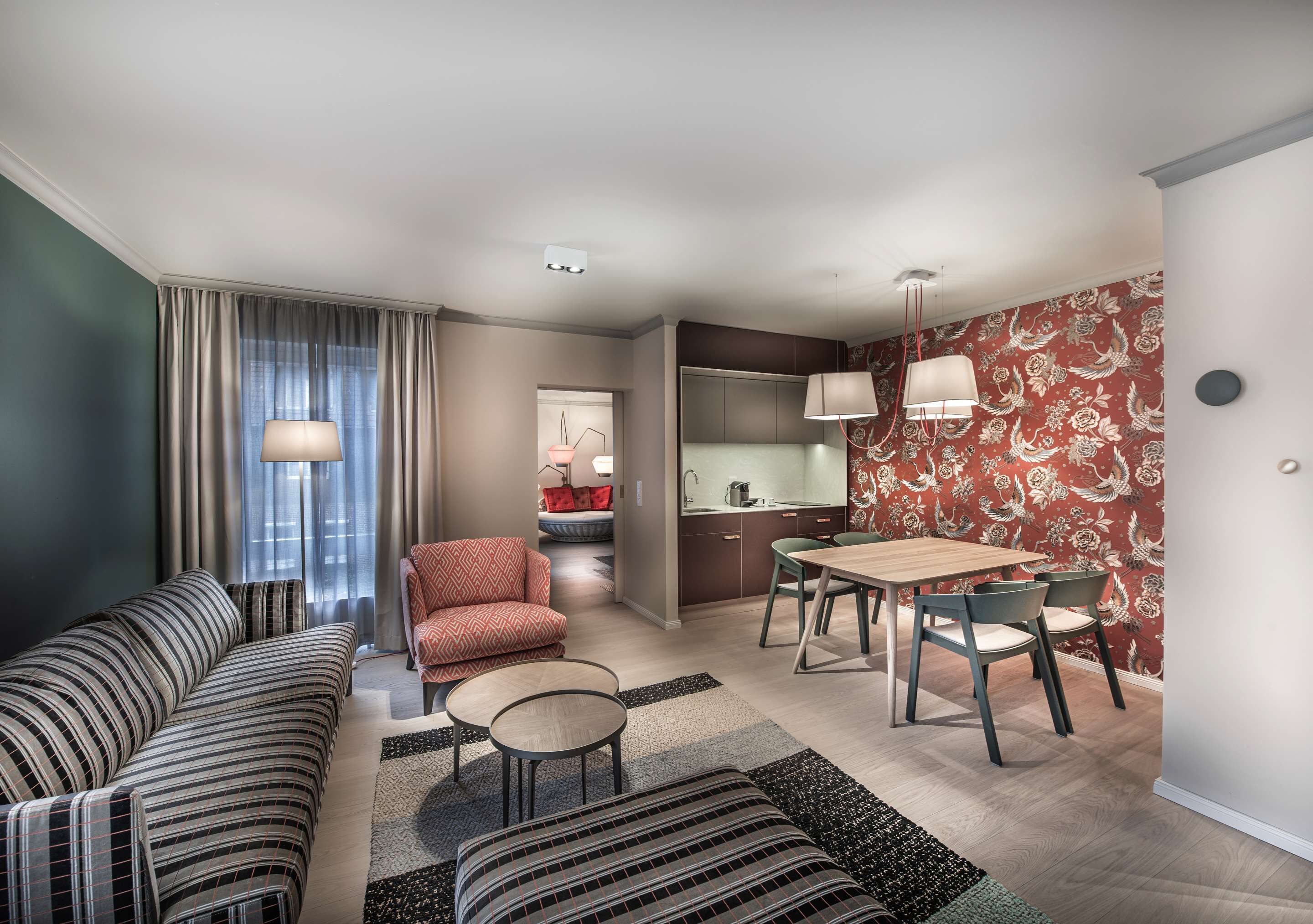 Ein modernes Wohnzimmer mit einer Couch, einem Sessel und einem Esstisch.