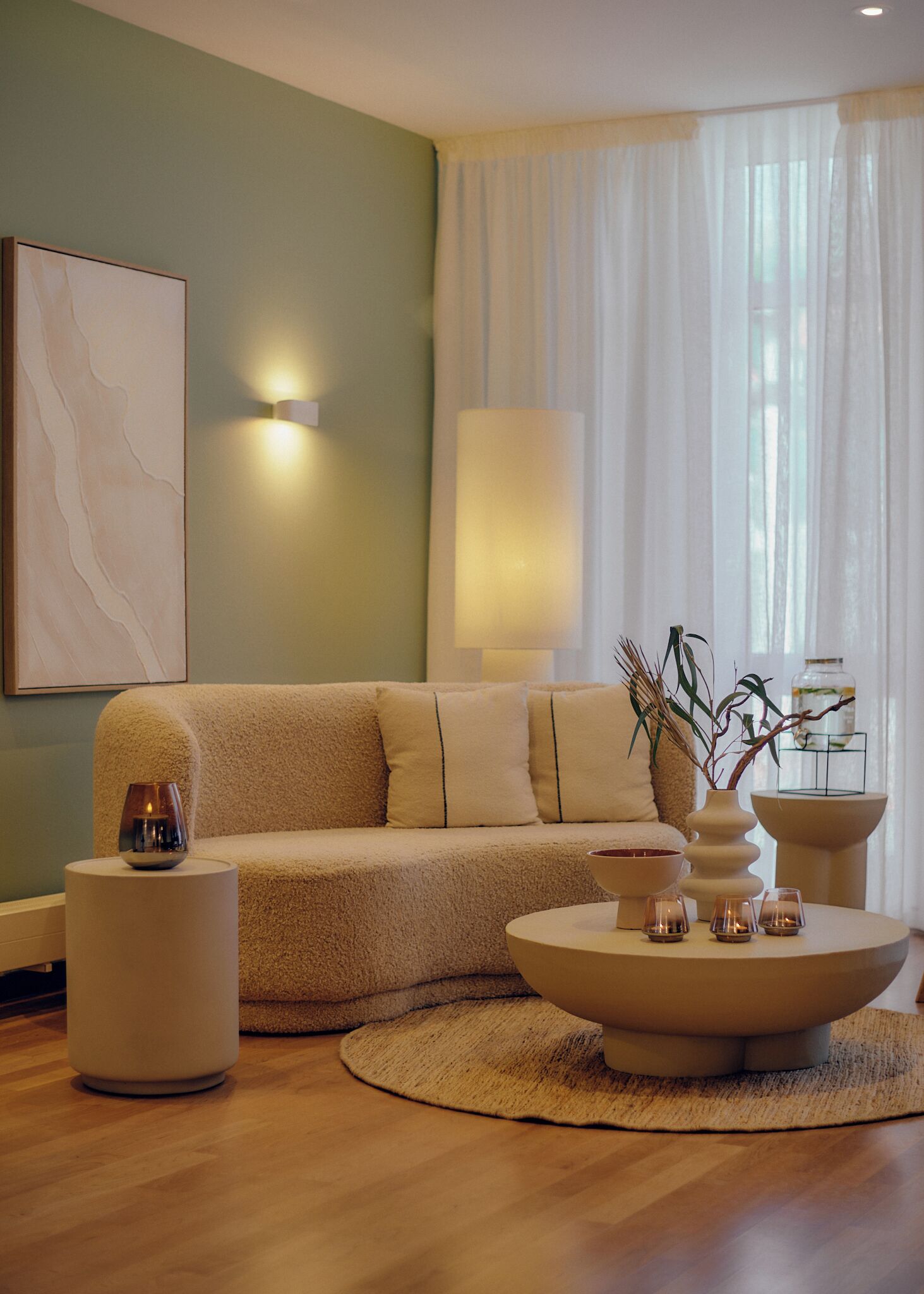 A modern living room with a beige sofa, a round coffee table, and a small side table.