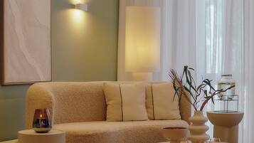 A modern living room with a beige sofa, a round coffee table, and a small side table.