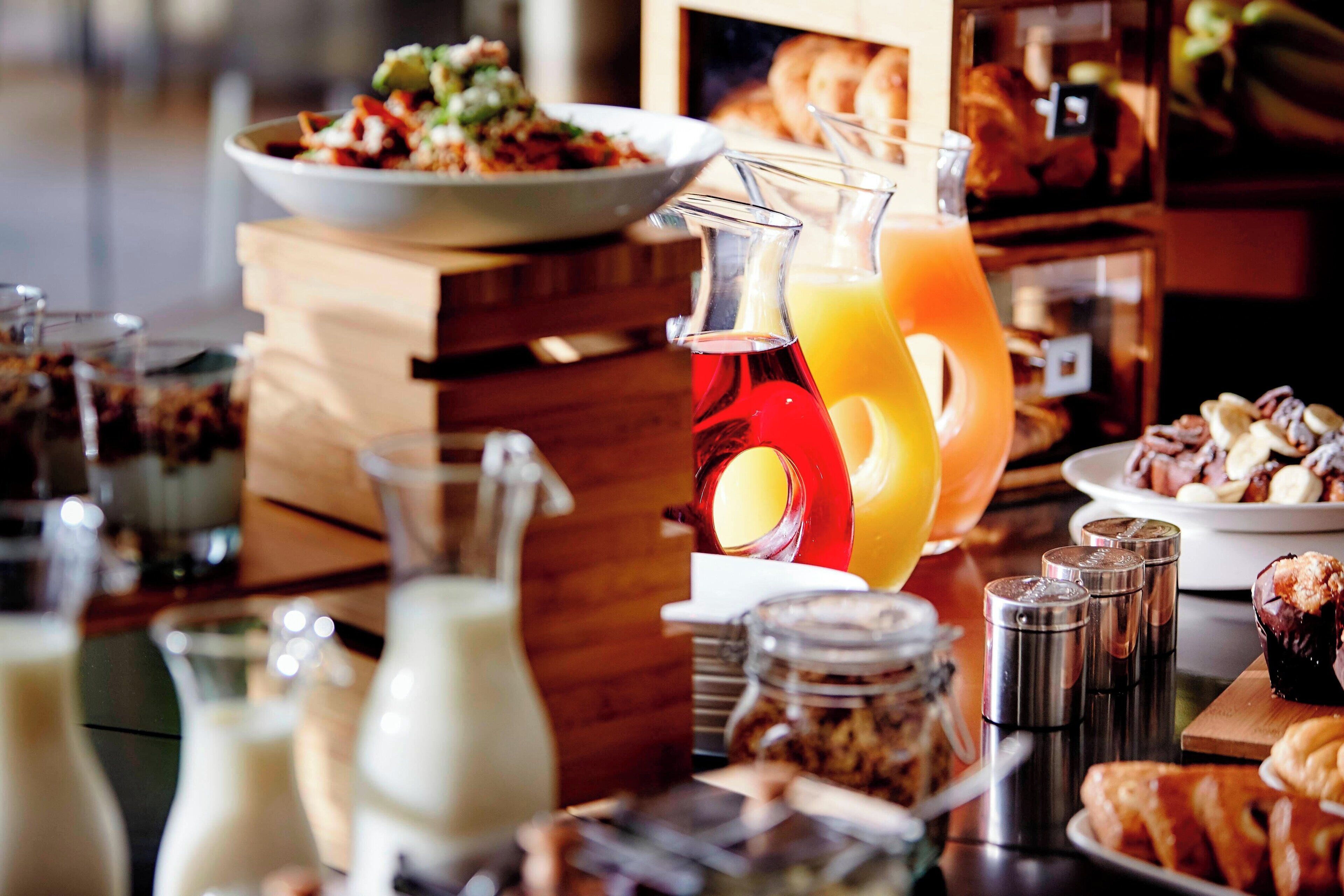 Un buffet de petit-déjeuner proposant une variété d’aliments, notamment des viennoiseries, des fruits et un assortiment de boissons.