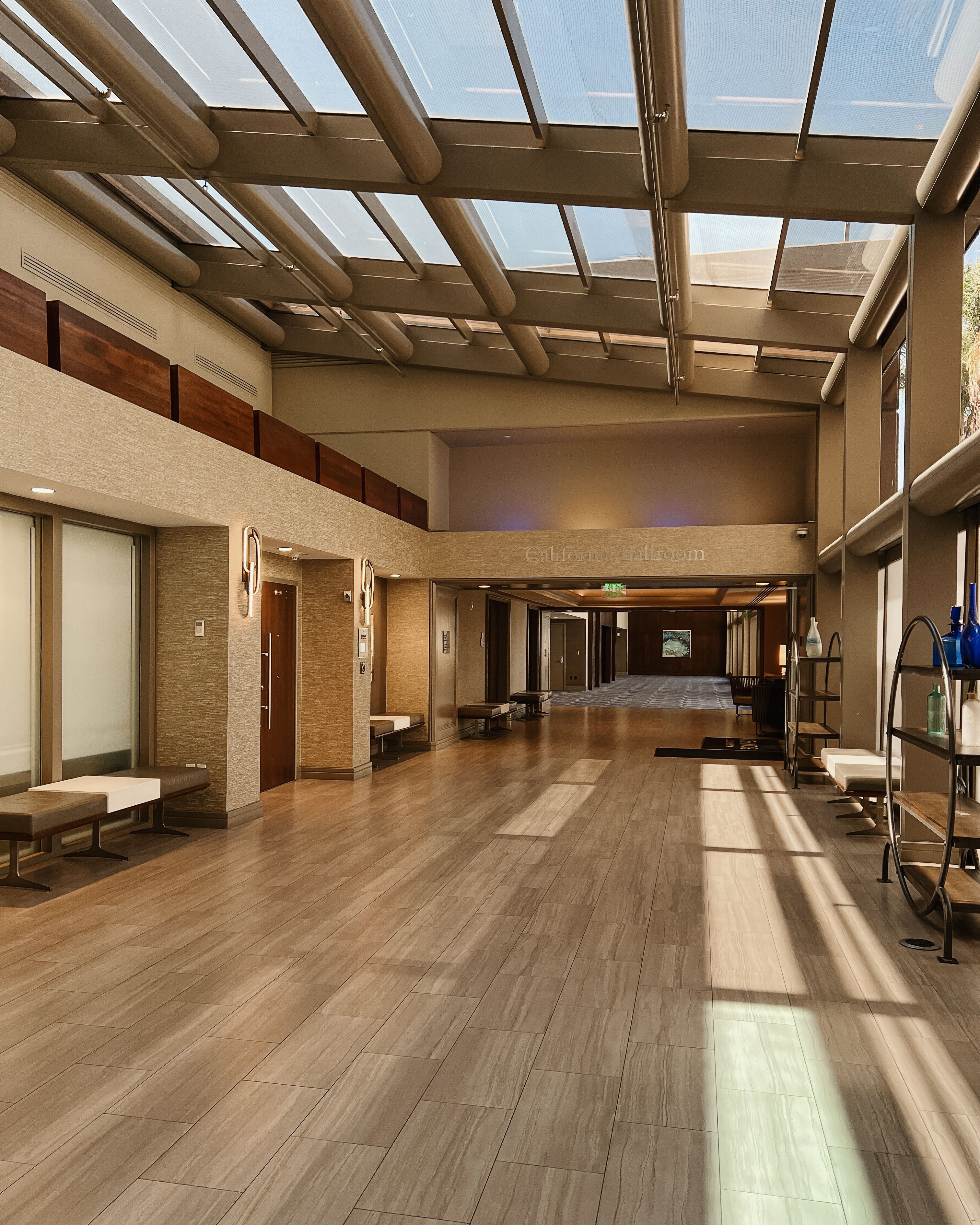 A spacious lobby with a high ceiling, wooden flooring, and a skylight.
