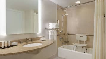 Een moderne badkamer met twee wastafels, een bad en een douche.