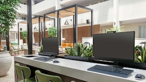A modern office space with two computer workstations, green chairs, and potted plants. - Embassy Suites by Hilton Philadelphia Valley Forge (Wayne)