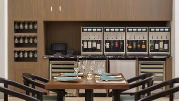 A restaurant with a wooden interior, a marble countertop, and a wine station with multiple bottles.