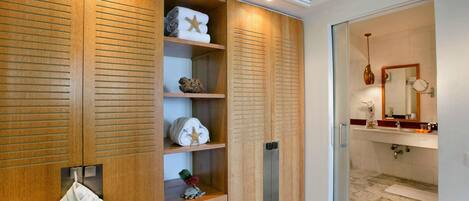 A modern bathroom with a marble floor, a sink with a mirror, and a towel rack with folded towels.
