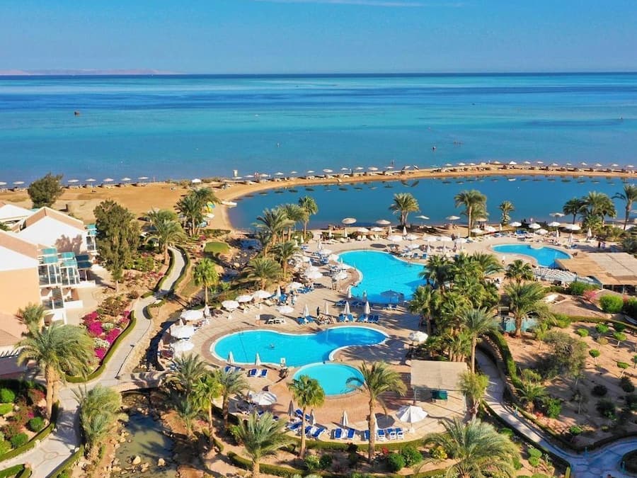 Een privéstrand, parasols, strandlakens, windsurfen