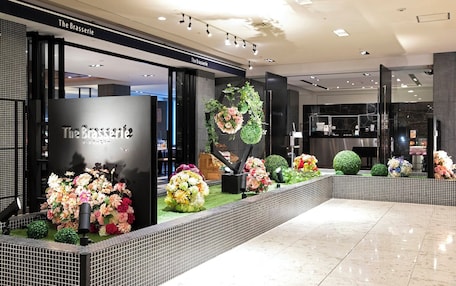 A modern interior with a reception area, a black reception desk, and a tiled floor.
