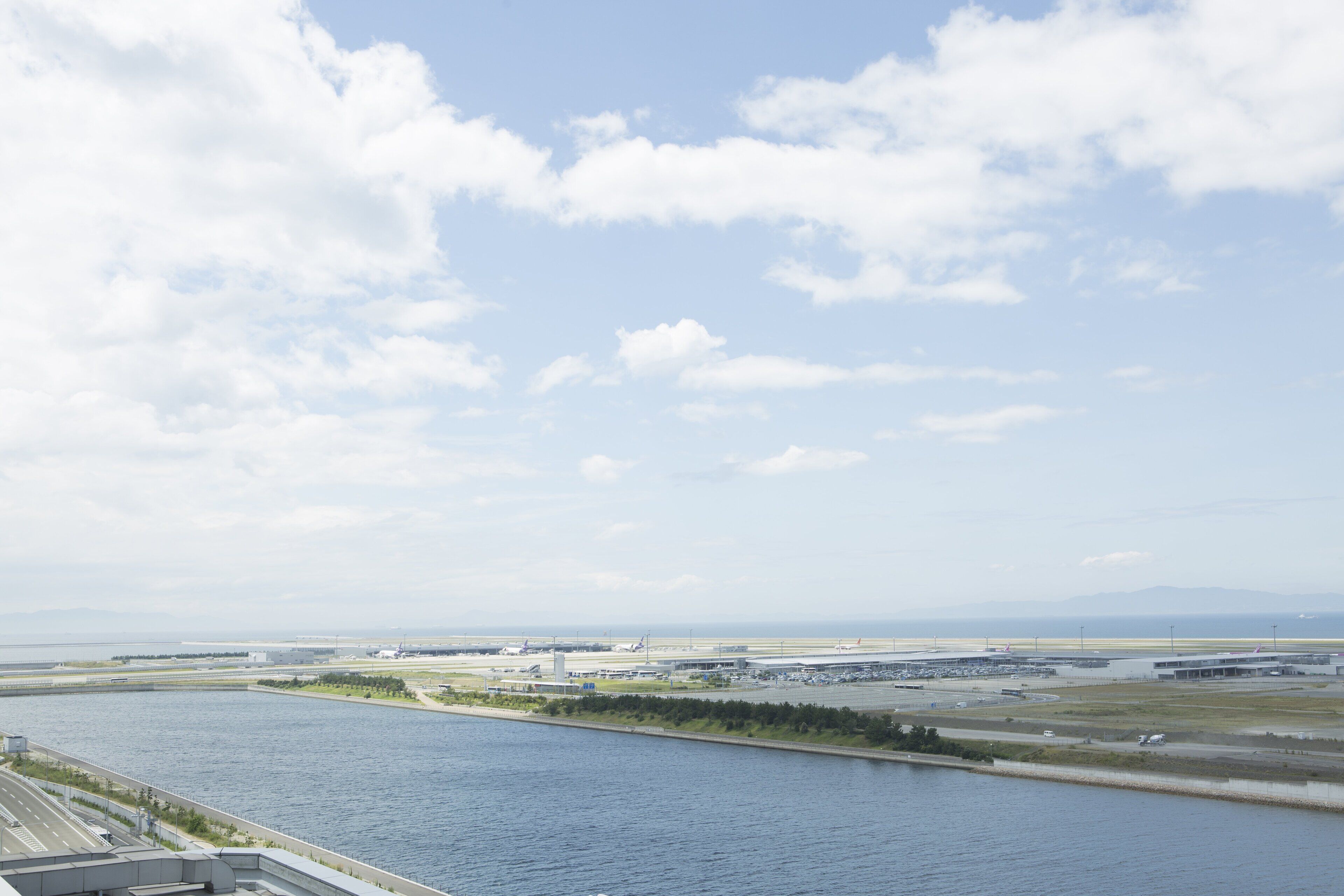 A view of an airport with a river in the foreground and a clear sky.