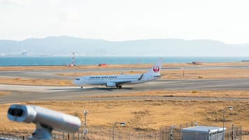 A Japan Airlines airplane on the runway with a mountainous backdrop.