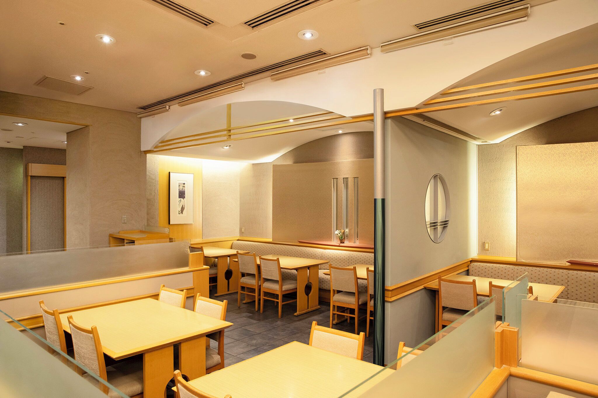 A modern restaurant with booth seating and a bar area.