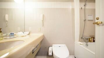 A bathroom with a toilet, sink, and shower.