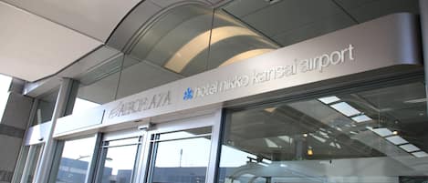 The exterior of the Hotel Nikko Kansai Airport, featuring a modern glass facade and signage.