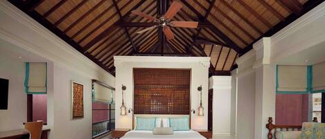 A spacious bedroom with a large bed, a ceiling fan, and a wooden ceiling.