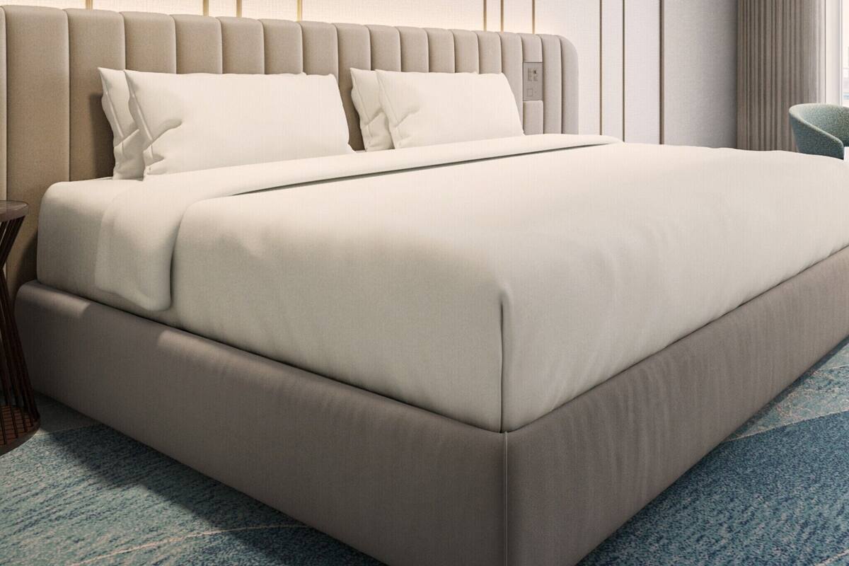 A modern hotel room with a large bed, a nightstand, and a chair.