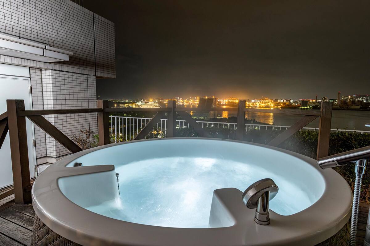 A hot tub with a city view at night.