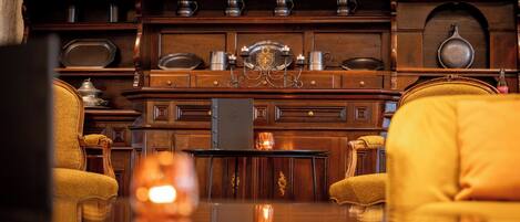 A room with wooden cabinetry, a table, and two yellow armchairs.