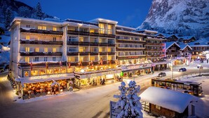 A multi-story hotel with balconies, a restaurant, and a ski resort in the background. - Hotel Kreuz & Post (Grindelwald)
