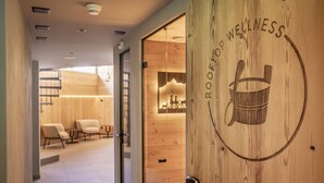 A wooden door with a wellness logo and a bucket symbol. - Hotel Kreuz & Post (Grindelwald)