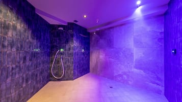 Experience a sleek, contemporary bathroom with a minimalist design, featuring a curved showerhead and recessed lighting.