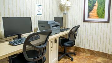 A workspace with two monitors, a printer, and a keyboard.