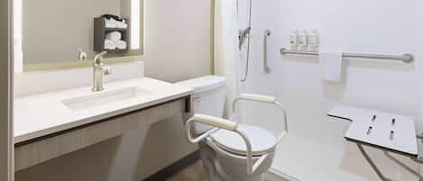 A modern bathroom with a white toilet, sink, and shower. There is a mirror above the sink, and a towel rack is visible on the wall.