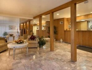 Relax in a spacious lobby with a high ceiling, polished floor, and comfortable seating area.