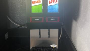 A beverage vending machine with two push buttons labeled "Orange" and "Apple".