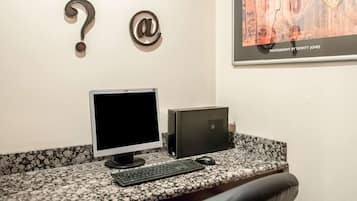A desktop computer setup with a monitor, keyboard, and mouse on a granite countertop.
