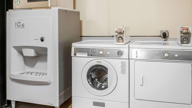 Un cuarto de lavandería con dispensador de agua, lavadora y secadora.
