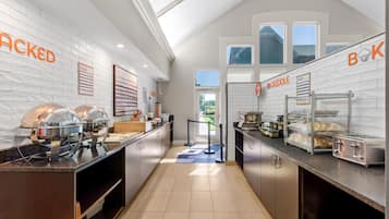 A modern kitchen with a buffet setup, including a food display and a griddle area.