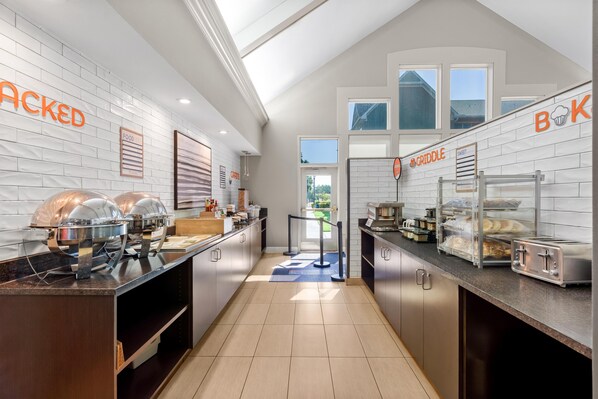 Una cocina moderna con barra tipo buffet, que incluye un mostrador de alimentos y una zona de plancha.