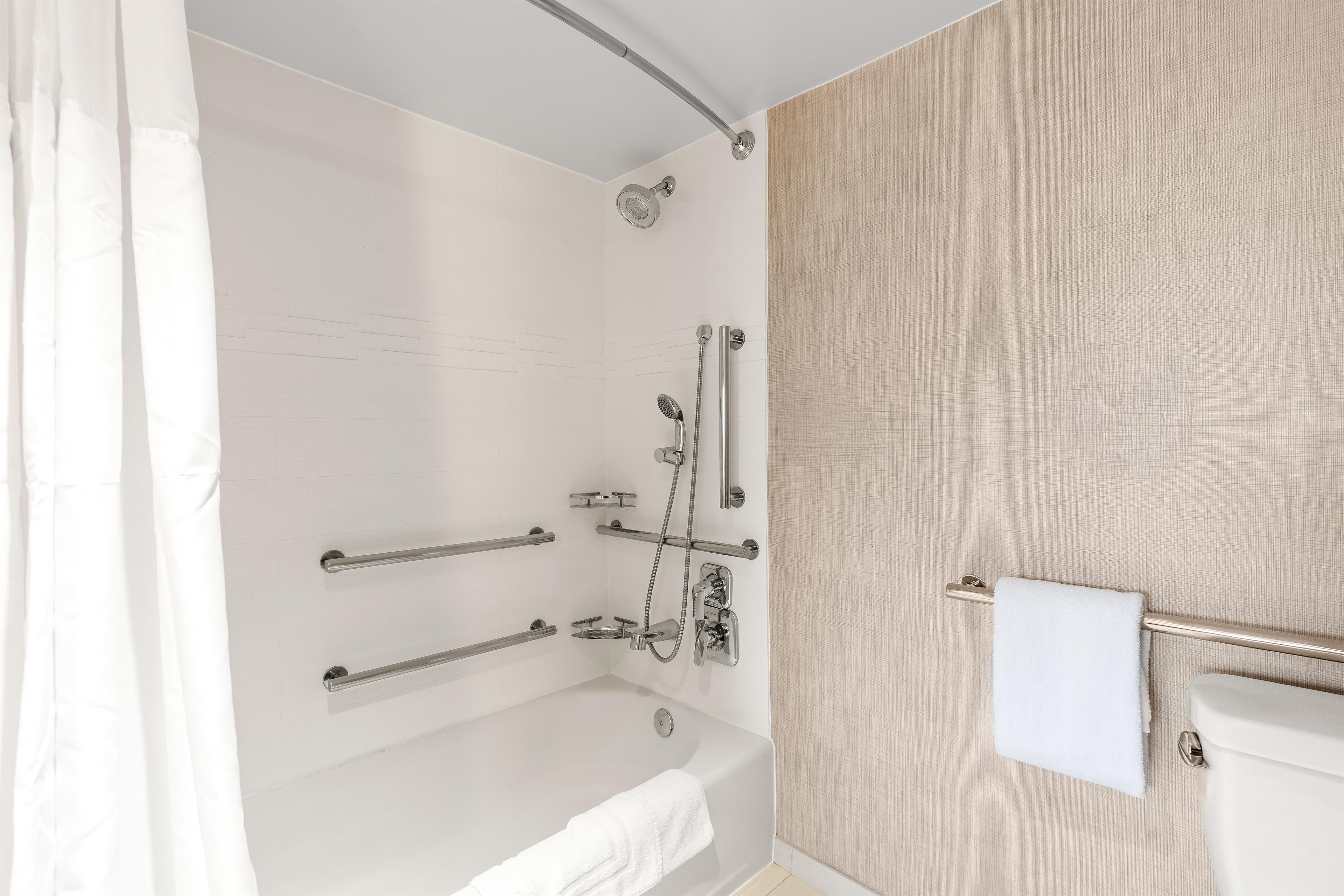 Une salle de bain moderne équipée d’une baignoire, d’une douche et de toilettes.