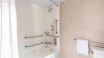 A modern bathroom with a bathtub, shower, and toilet.